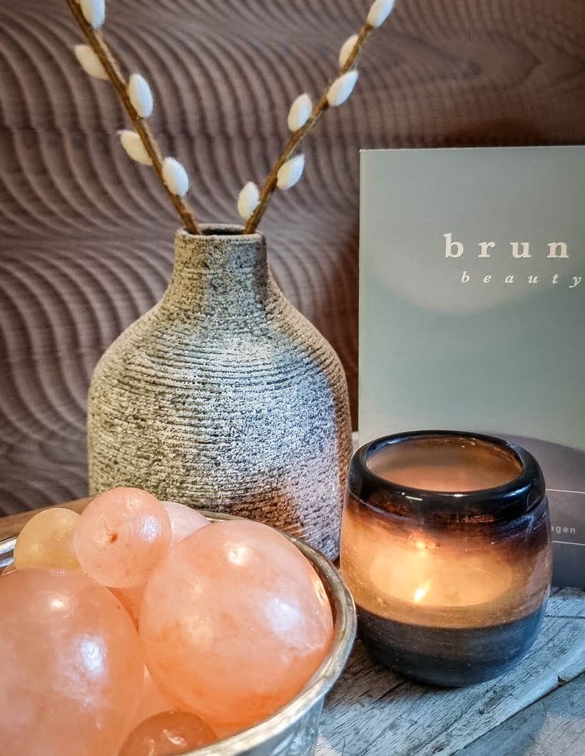 Wellness-Arrangement: Salzkugeln, Kerzen und Brune Beauty Flyer im Hotel Seesteg